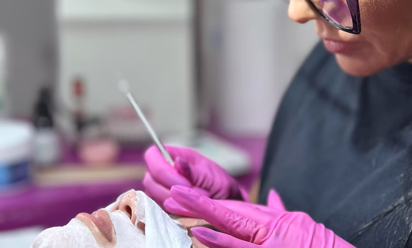 Esteticista realizando limpeza de pele em modelo durante curso presencial, Instituto Lilly Santos